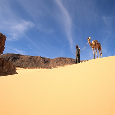 image/2e55f11c8669d08bb1dd01acd711fcb2_Man_met_kameel_in_woestijn.jpg